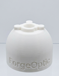 A white 3D-printed dome-shaped capsulorhexis simulator with the brand name 'ForgeOptic' embossed on the front, displayed on a clear acrylic stand against a light gray background.